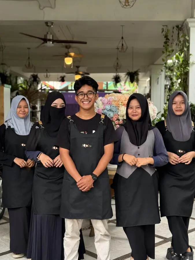 Tim Pojoke Segara berseragam hitam berfoto bersama di dalam kafe
