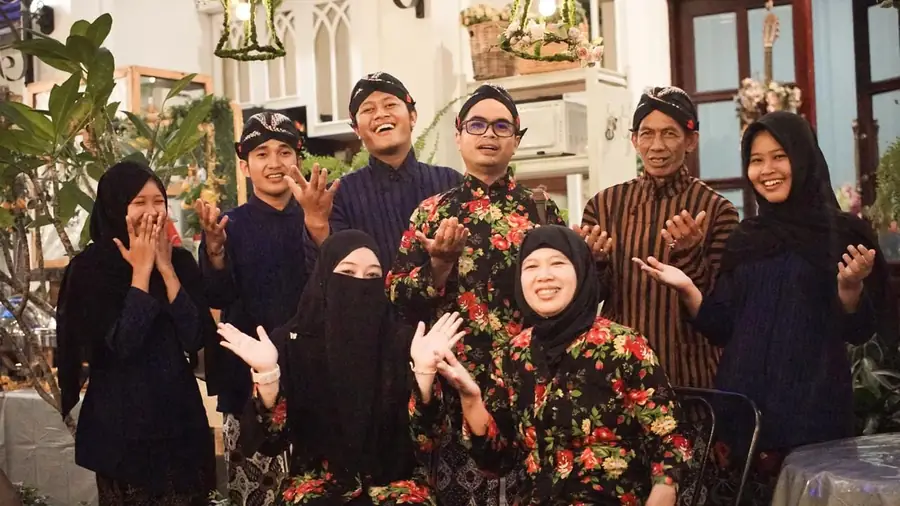 Tim Pojoke Segara berpakaian adat Jawa tersenyum bersama di kafe