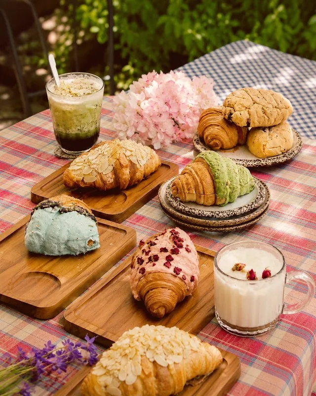 Croissant aneka rasa dan segelas minuman di atas talenan